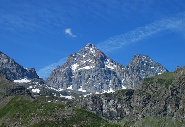 Il monviso con qualche sprazzo di neve si staglia su un cielo azzurro con striature di nuvole